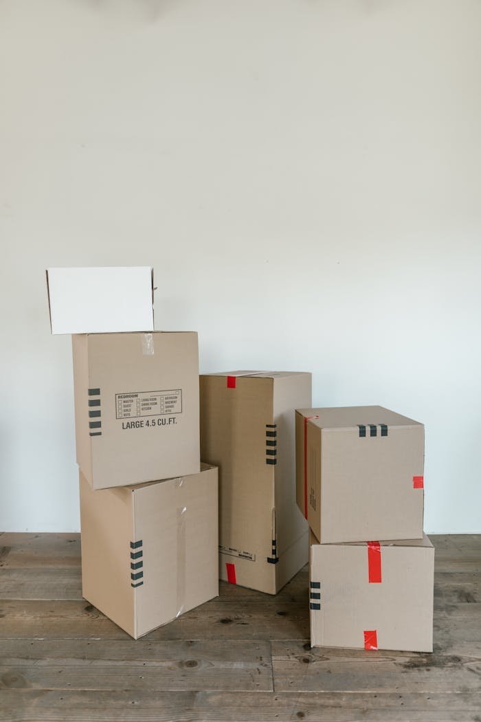 A stack of various cardboard boxes ready for moving or shipping indoors.